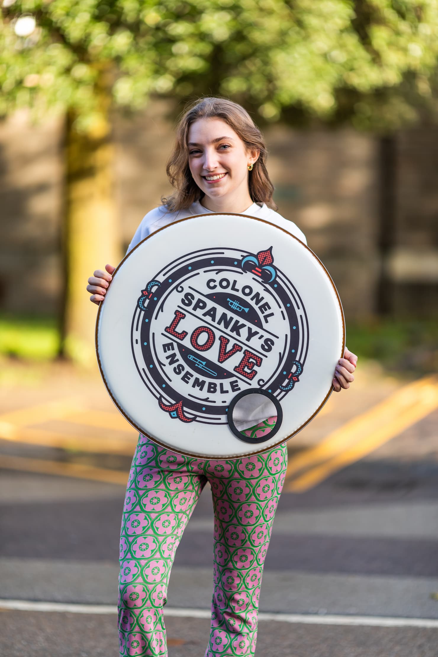 Zoe holding the Colonel Spanky's logo on a drum skin